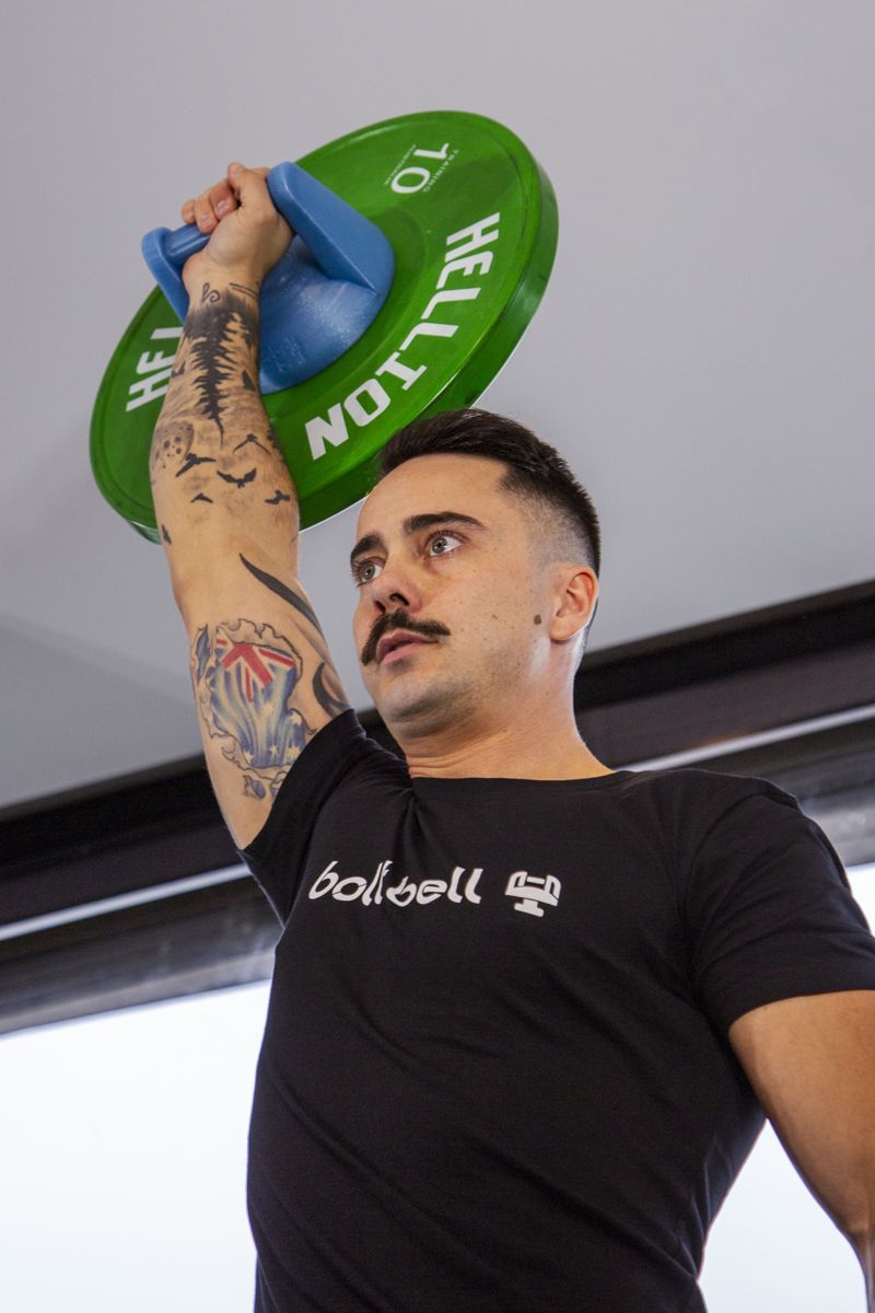 Athlete training with Bolt Bell weight plate handles